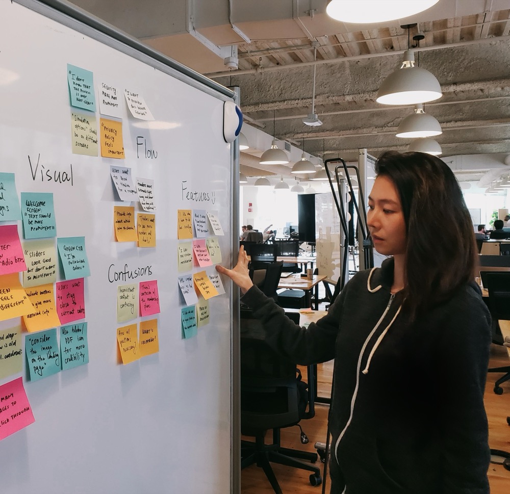 Marina Tai leading an affinity mapping session at a whiteboard